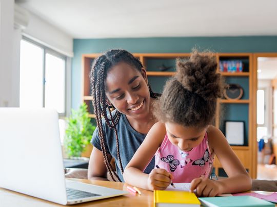 Foster carer working at home with foster child